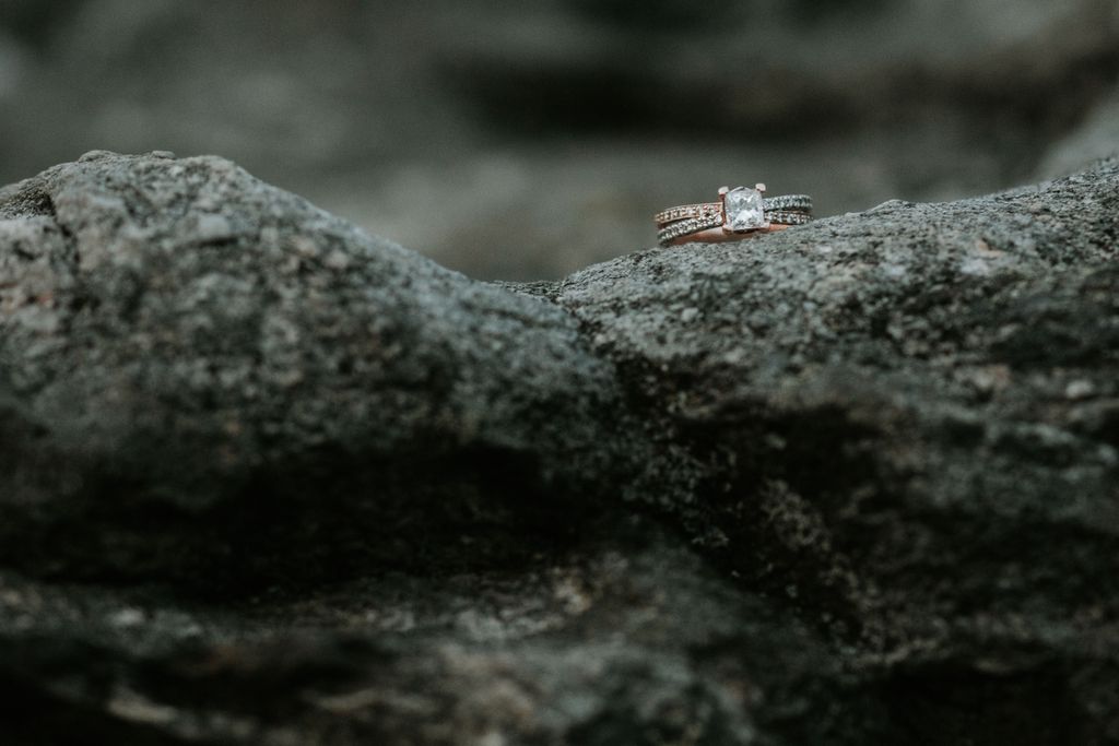 Princess cut ring with mixed metal band sitting on a rock Princess cut ring with mixed metal band sitting on a rock