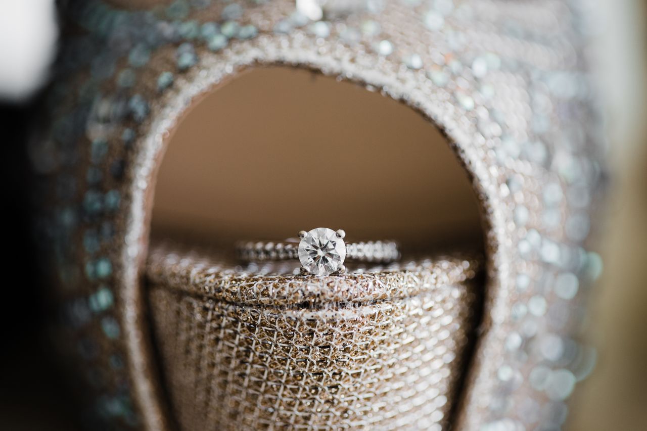 A side stone engagement ring sits on top of a sparkly heel A side stone engagement ring sits on top of a sparkly heel