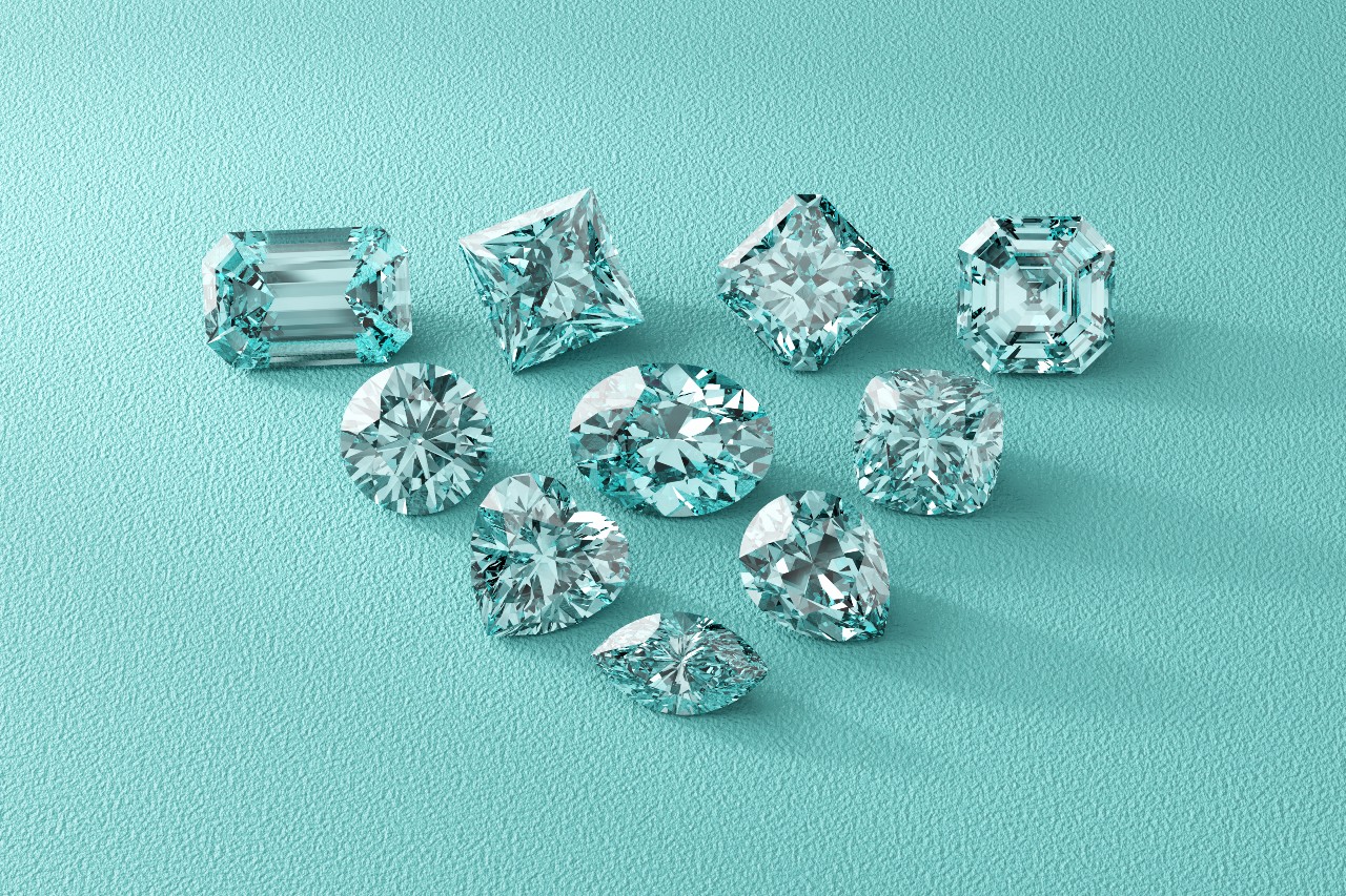 A variety of lab-grown diamonds showcases all the popular gem cuts as they sit on a teal leather fabric A variety of lab-grown diamonds showcases all the popular gem cuts as they sit on a teal leather fabric