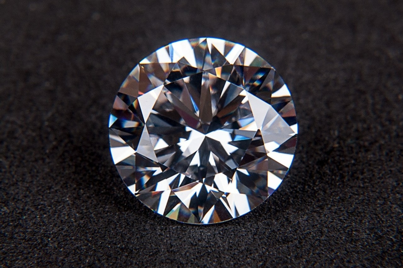 A close-up of a stunning round-cut diamond on a soft black backdrop.