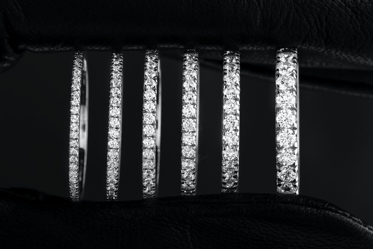 a row of pave wedding bands on a black background