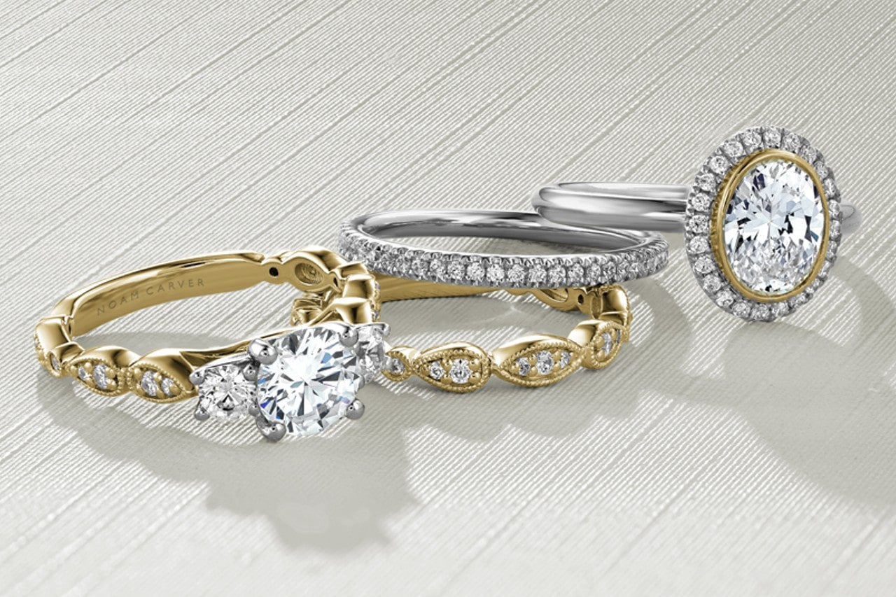 Two engagement rings and two wedding bands by Noam Carver stacked together