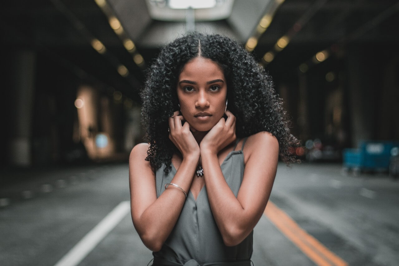 A fashionable young woman standing in a tunnel, wearing elegant and delicate fashion jewellery.