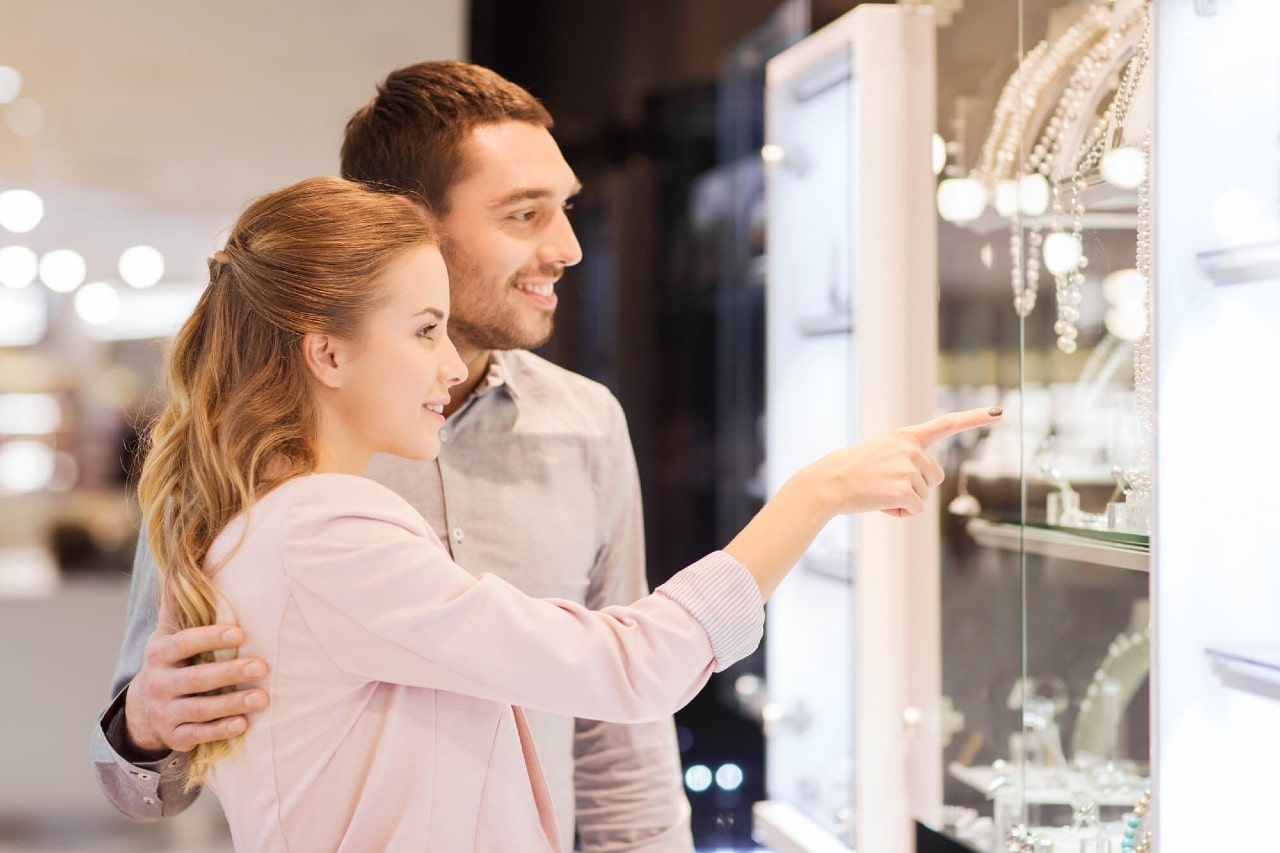 A young couple window shopping at a jewellery store.