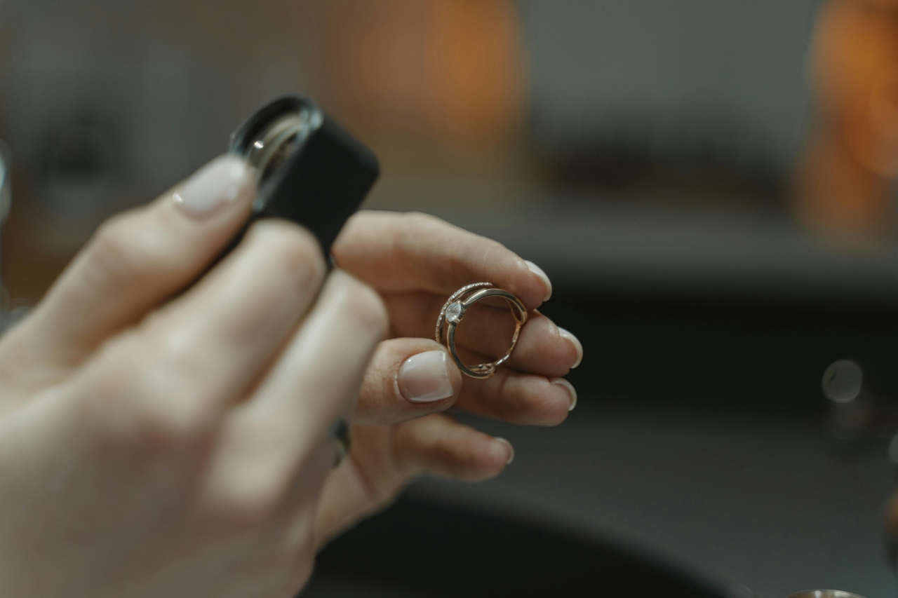 A jeweller examining an engagement ring under a magnifying lens.