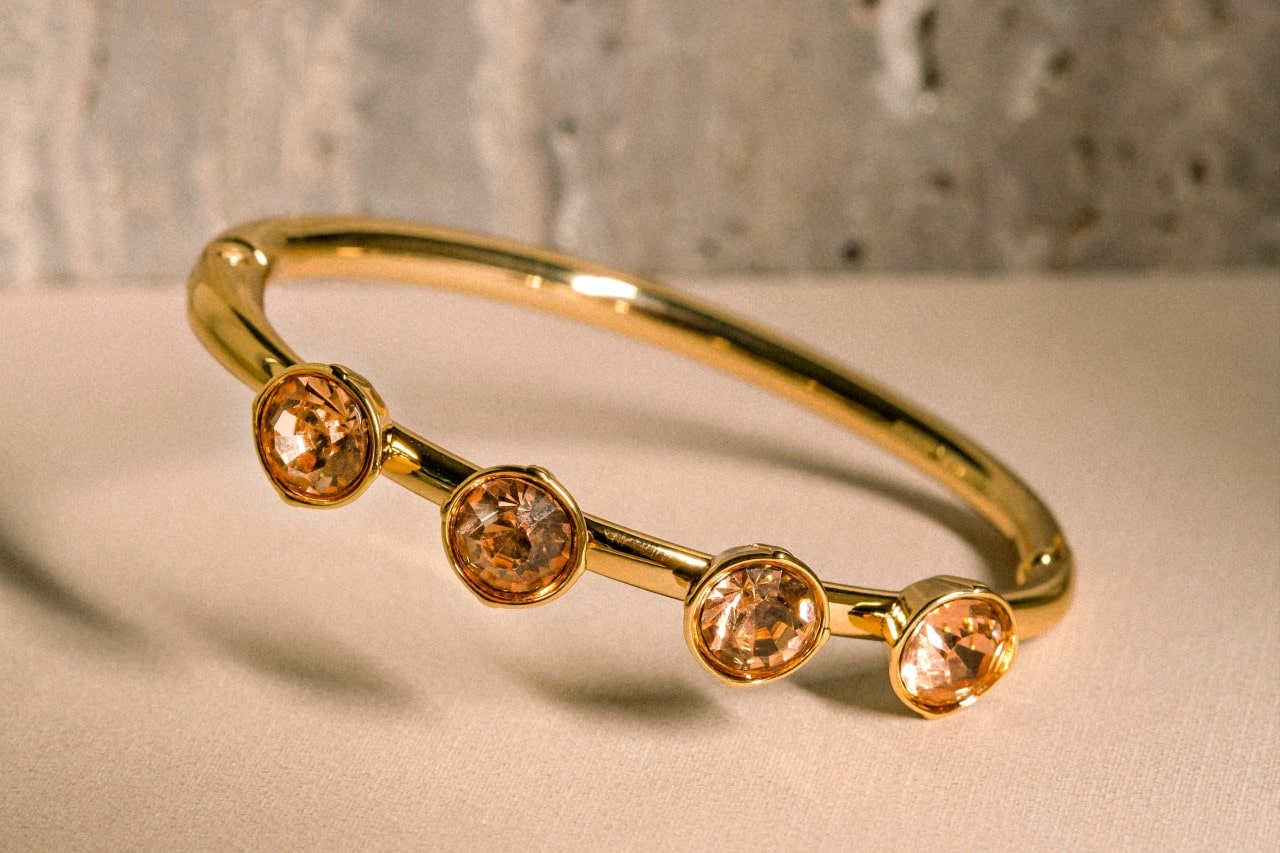 A yellow gold fashion ring featuring four bezel set orange gemstones.